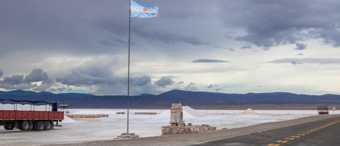 Vista panorámica de las salinas argentinas con una bandera nacional, símbolo del potencial minero del país impulsado por el litio, el cobre y el oro.