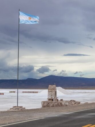 Vista panorámica de las salinas argentinas con una bandera nacional, símbolo del potencial minero del país impulsado por el litio, el cobre y el oro.
