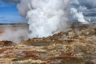 Campo geotérmico con vapor emergiendo del suelo, asociado a salmueras geotérmicas con potencial para la extracción de litio.