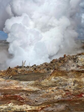 Campo geotérmico con vapor emergiendo del suelo, asociado a salmueras geotérmicas con potencial para la extracción de litio.