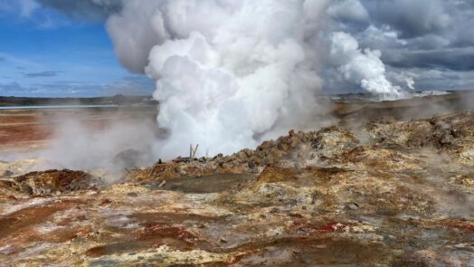 Campo geotérmico con vapor emergiendo del suelo, asociado a salmueras geotérmicas con potencial para la extracción de litio.