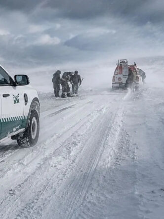 Camionetas de Gendarmería y personal de rescate en una ruta cubierta de nieve, en el marco de Río Tinto bajo investigación por el accidente de los mineros de Fénix varados en la nieve.