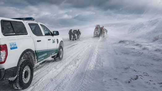 Camionetas de Gendarmería y personal de rescate en una ruta cubierta de nieve, en el marco de Río Tinto bajo investigación por el accidente de los mineros de Fénix varados en la nieve.