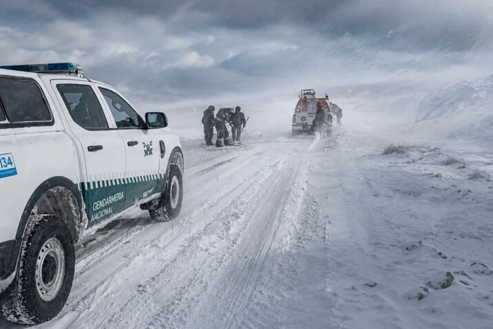 Camionetas de Gendarmería y personal de rescate en una ruta cubierta de nieve, en el marco de Río Tinto bajo investigación por el accidente de los mineros de Fénix varados en la nieve.