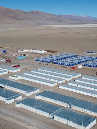 Vista aérea de un campamento minero de alta montaña, con módulos habitacionales e instalaciones operativas para el desarrollo de un proyecto de litio en la Puna argentina.