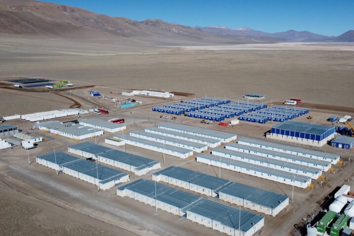Vista aérea de un campamento minero de alta montaña, con módulos habitacionales e instalaciones operativas para el desarrollo de un proyecto de litio en la Puna argentina.