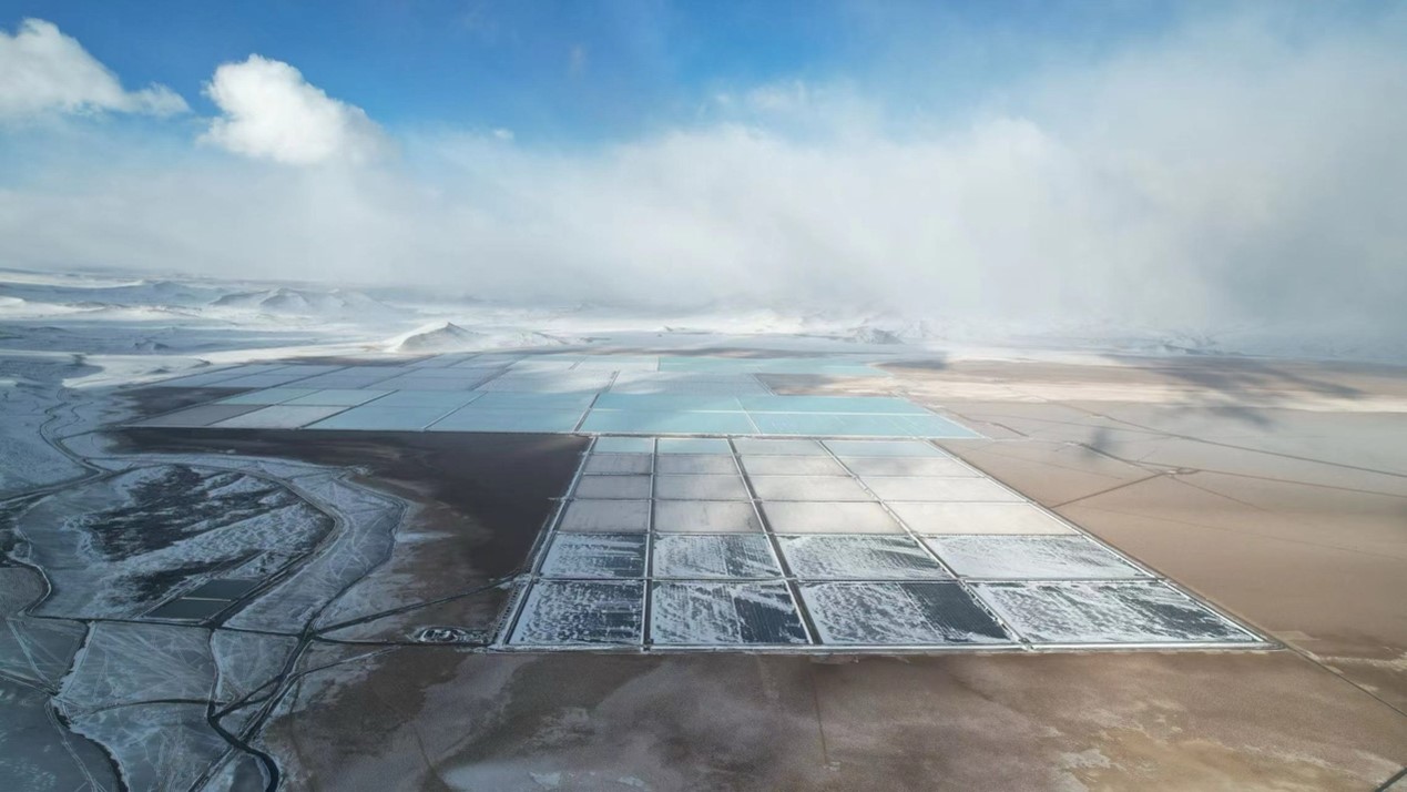 Vista aérea de piletas de evaporación del Proyecto Mariana, con sectores cubiertos por nieve y salmueras de litio en diferentes etapas de concentración.