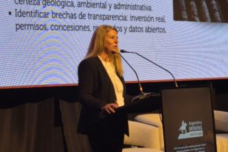 Una expositora en el escenario de Argentina Mining 2026 frente a una pantalla sobre indicadores y transparencia para la exploración minera en Salta y Jujuy.