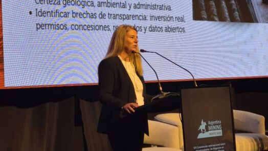 Una expositora en el escenario de Argentina Mining 2026 frente a una pantalla sobre indicadores y transparencia para la exploración minera en Salta y Jujuy.