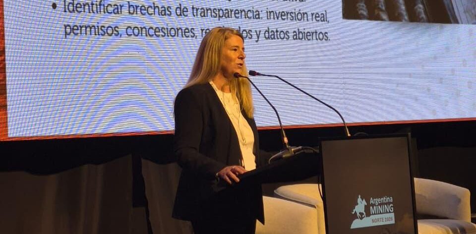 Una expositora en el escenario de Argentina Mining 2026 frente a una pantalla sobre indicadores y transparencia para la exploración minera en Salta y Jujuy.