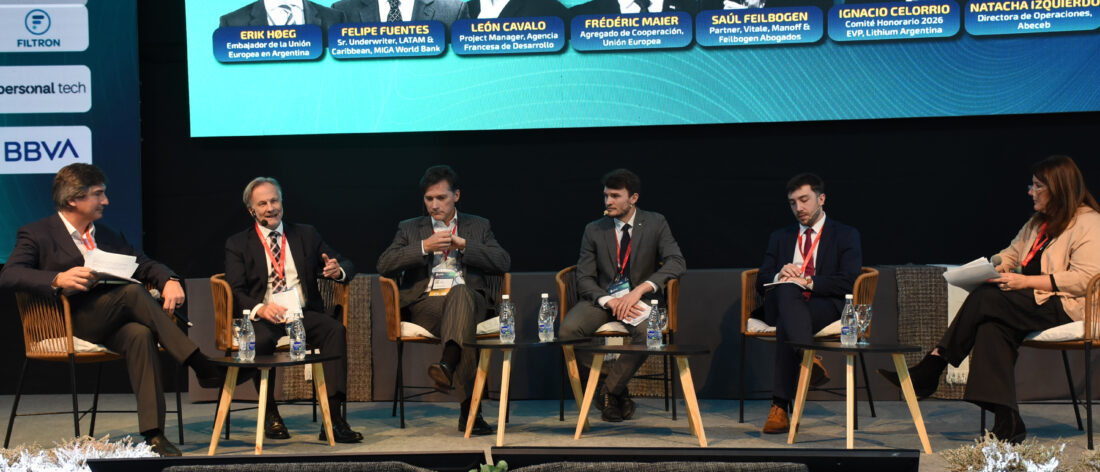 Panelistas y moderadores sentados sobre el escenario de Litio en Sudamérica 2026, con una pantalla que identifica a los participantes.