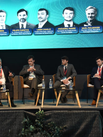 Panelistas y moderadores sentados sobre el escenario de Litio en Sudamérica 2026, con una pantalla que identifica a los participantes.
