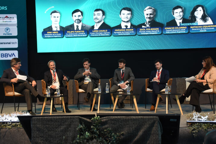 Panelistas y moderadores sentados sobre el escenario de Litio en Sudamérica 2026, con una pantalla que identifica a los participantes.